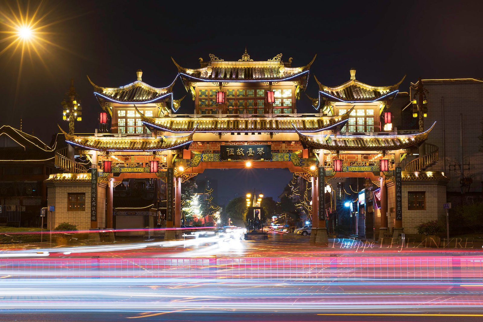 QinTaiLu gate at night with car light trails in Chengdu, Sichuan province, China