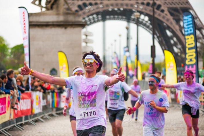Paris, France - April 13, 2014: People covered with colored powder finishing the color run race under the Eiffel Tower.
