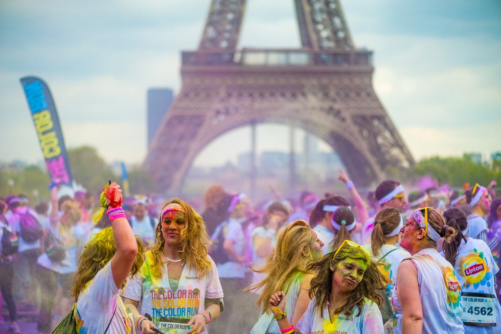 Paris, France - April 13, 2014: People enjoying the party with colorful powder under the Eiffel Tower after the color run race.