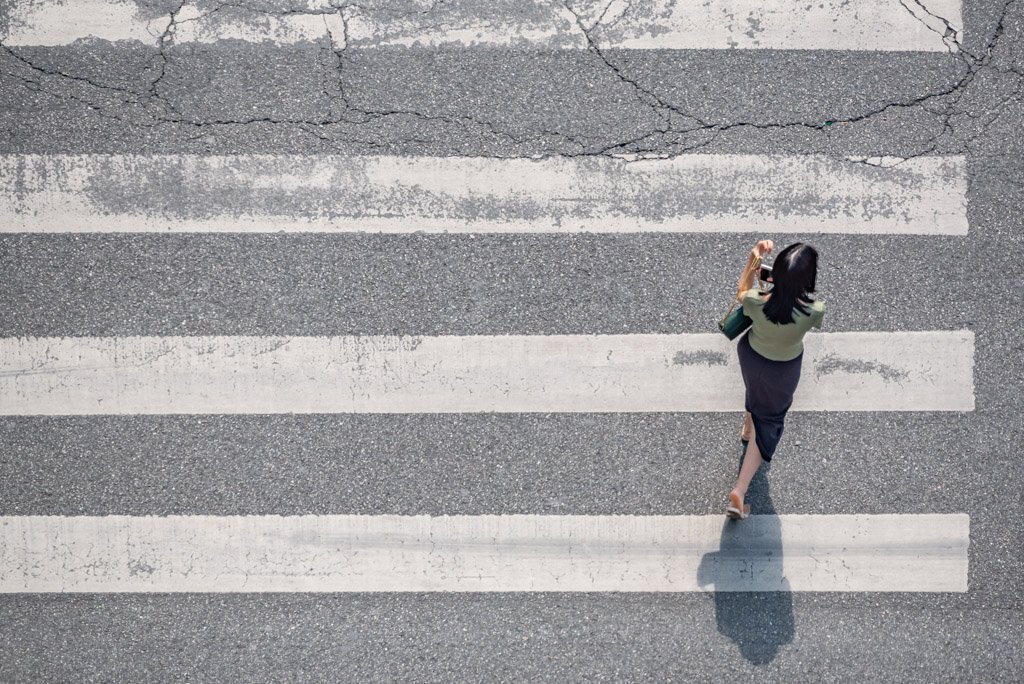 Young woman crossing the street aerial view in Chengdu, Sichuan province, China