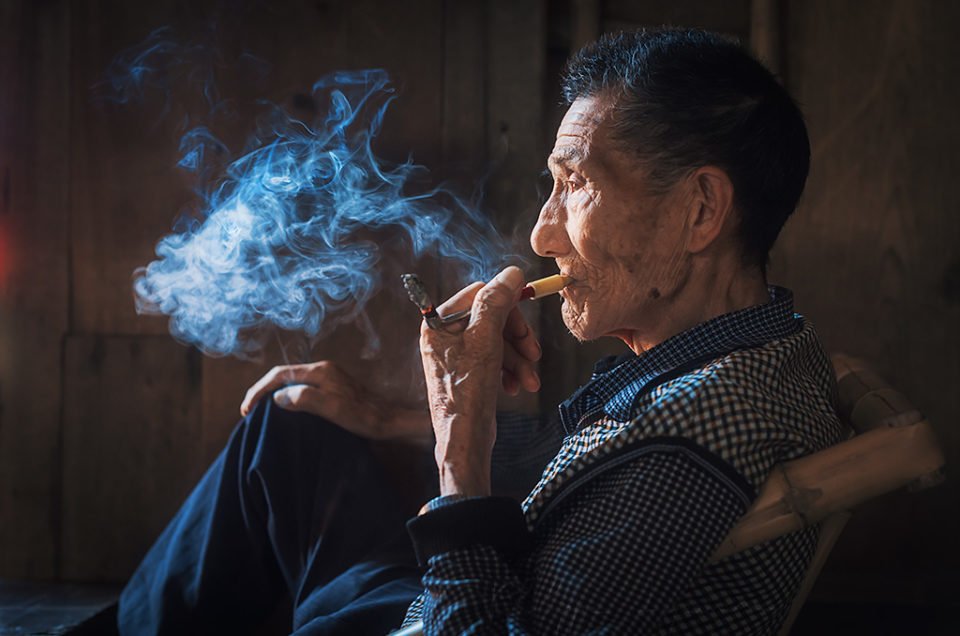 Portrait of an old chinese man smoking in an ancient tearoom in Chengdu, Sichuan Province, China
