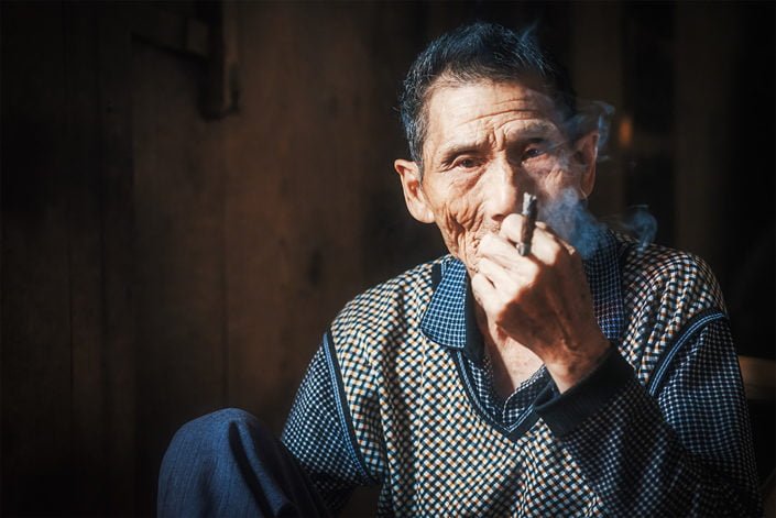 Portrait of an old chinese man smoking in an ancient tearoom, Chengdu, Sichuan province, China