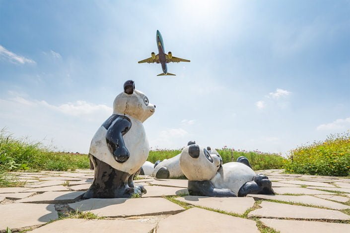 Panda statues and airplane against sky near Chengdu airport, Sichuan province, China