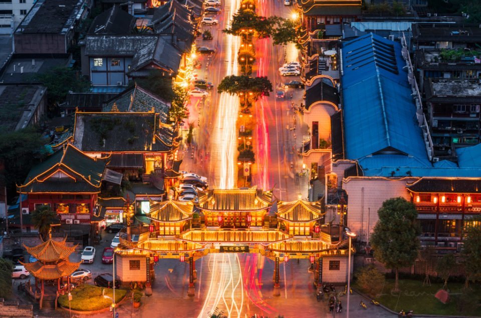 QinTaiLu chinese traditional gate illuminated at night aerial view with car light trails, Chengdu, China