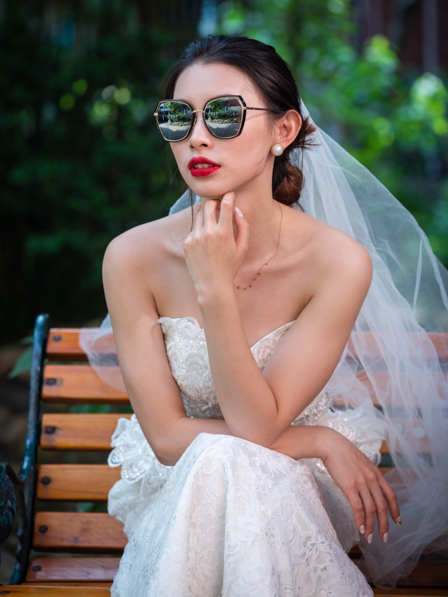 Young chinese bride with sunglasses sitting on a bench in Chengdu, Sichuan province, China