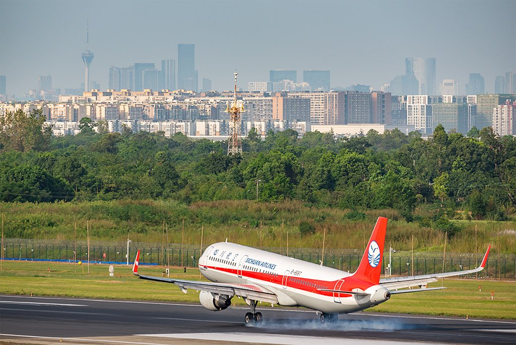 Sichuan airlines airplane landing in Chengdu with the city in the background, Sichuan province, China
