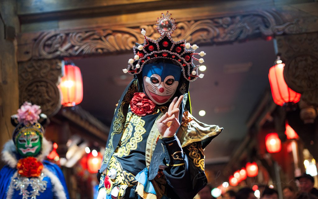 Chinese actor performs a public traditional face-changing art or bianlian onstage at Chunxifang Chunxilu covered street, Chengdu, Sichuan province, China