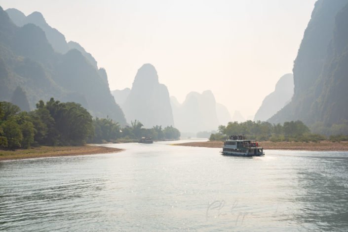 Li River cruise between Guilin and Yangshuo with limestone karst hills foggy landscape in Guangxi province, China