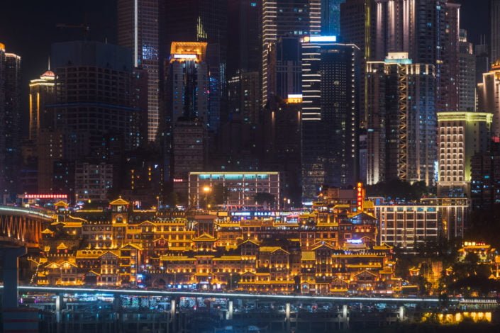 Skyscrapers and Hongya cave illuminated at night in Chongqing, China
