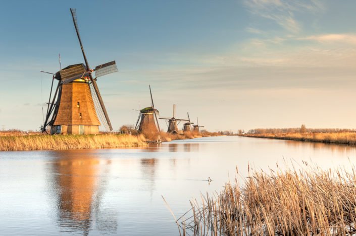 Windmills alignment reflecting in the water in Kinderdijk, Netherlands