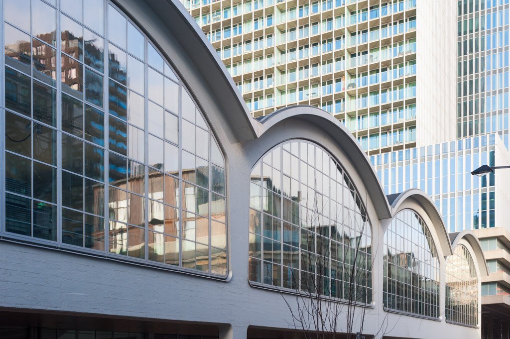 Rotterdam, Netherlands : Rotterdam cruise terminal arch windows with buildings in the background in Wilhelminapier district.