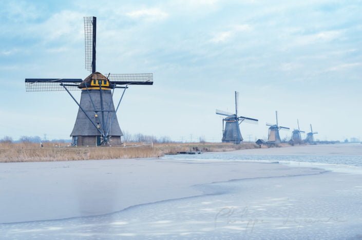 Windmills in winter with frozen water in a canal in Kinderdijk, Netherlands