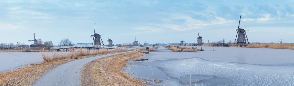 Windmills in winter panorama with frozen water in a canal in Kinderdijk, Netherlands