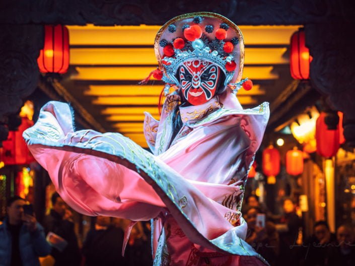 Chinese actress performs a public traditional face-changing art or bianlian onstage at Chunxifang Chunxilu covered street, Chengdu, Sichuan province, China