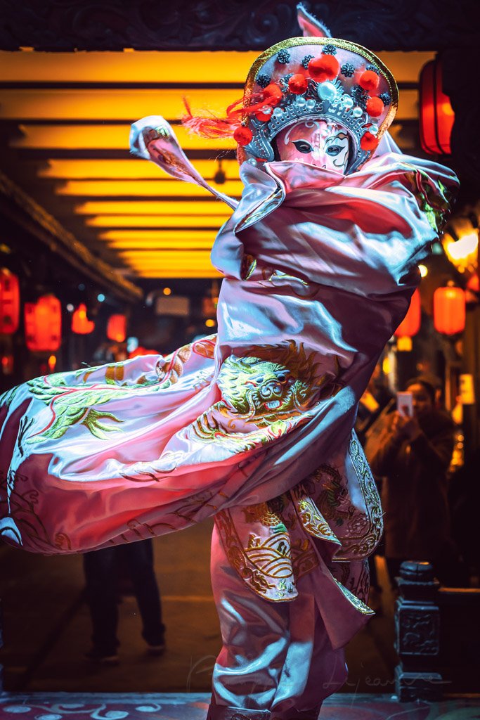 Chinese actress performs a public traditional face-changing art or bianlian onstage at Chunxifang Chunxilu covered street, Chengdu, Sichuan province, China