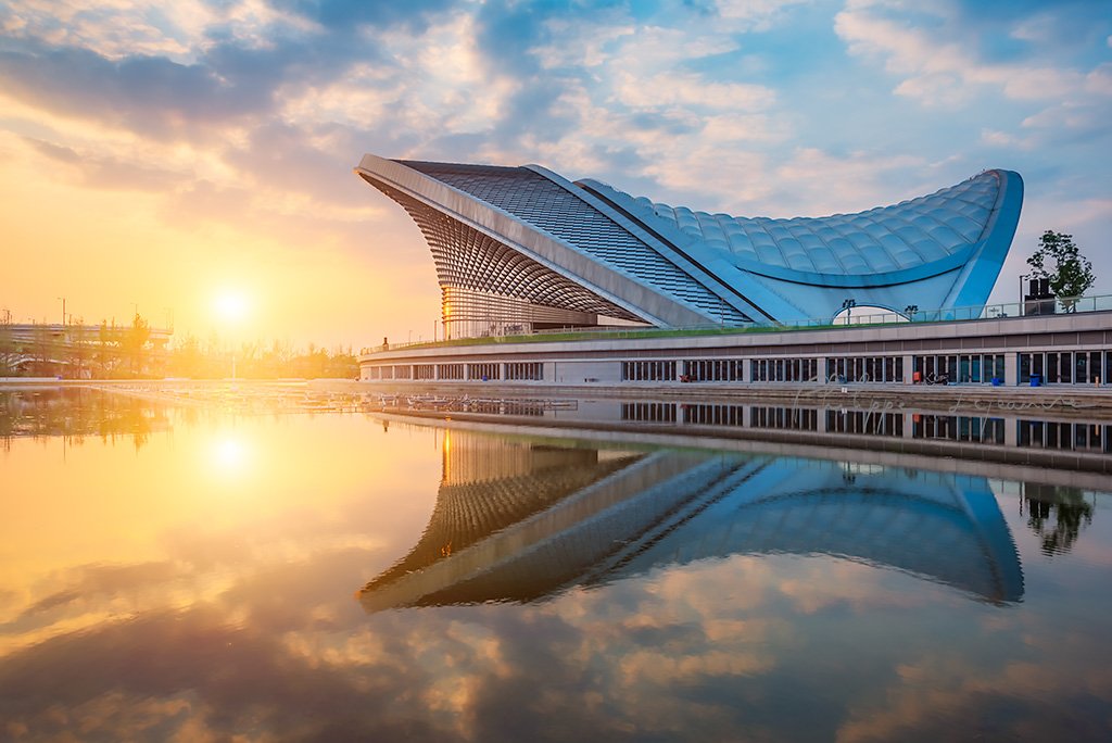 Chengdu open air music park modern building with futuristic architecture reflecting in a pond, Sichuan province, China