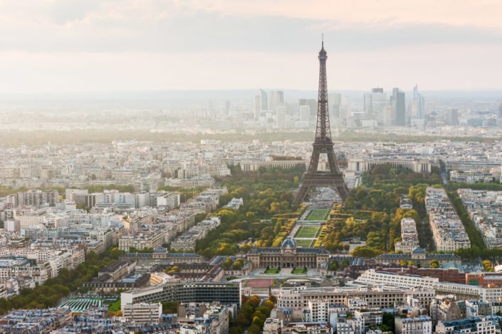 Paris skyline with the Eiffel tower and La Defense business district in the haze in the background, France