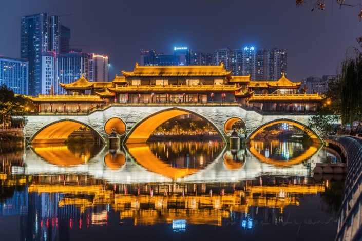 Anshun bridge illuminated at night and reflecting in JinJiang river in Chengdu, Sichuan province, China