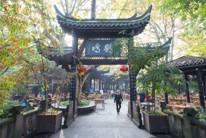 Chengdu, China : People's park famous HeMing teahouse main gate with sunrays passing thought trees on a hazy day.