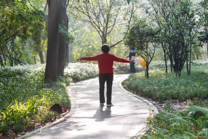 Chengdu, China : Senior woman practising dance with a fan in People's park on a hazy day.