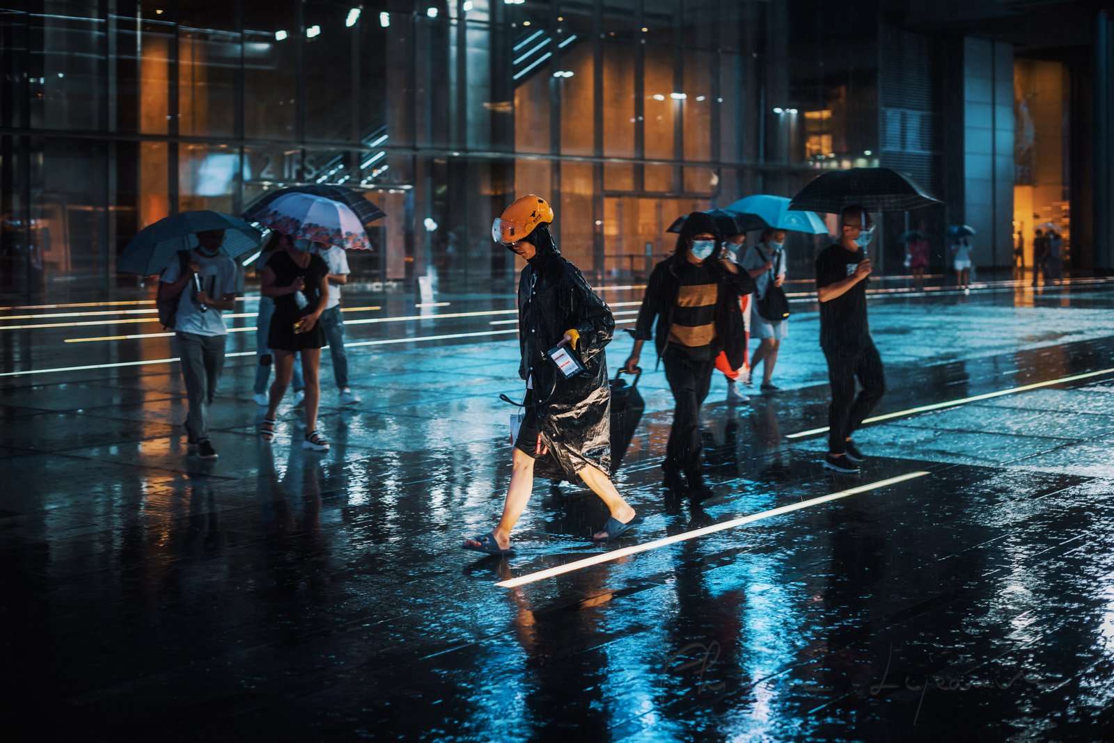 Delivery man rushing in the street under the rain at night near International Finance Square - IFS -, Chengdu, Sichuan province, China