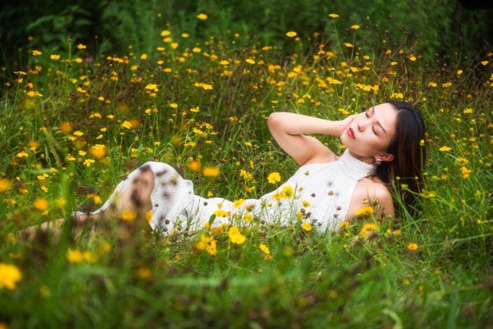 Young Chinese woman wearing a white dress in nature in Chengdu, Sichuan province, China