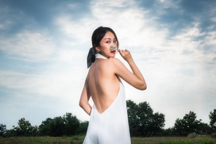 Young Chinese woman wearing a white dress in nature in Chengdu, Sichuan province, China