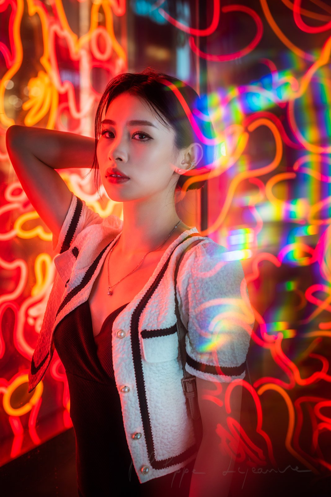 Young chinese woman standing next to red neon lights in Chengdu, Sichuan province, China