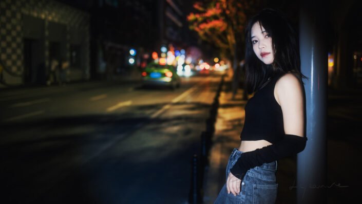 Young Chinese woman in the street portrait in a spotlight at night in Chengdu