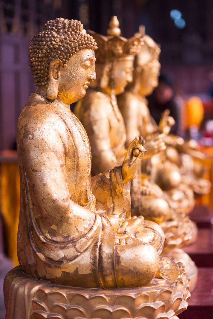 3 gold colored buddha statues at the entry of DaCiShi Temple, a buddhist temple in the center of the city, Chengdu, Sichuan Province, China