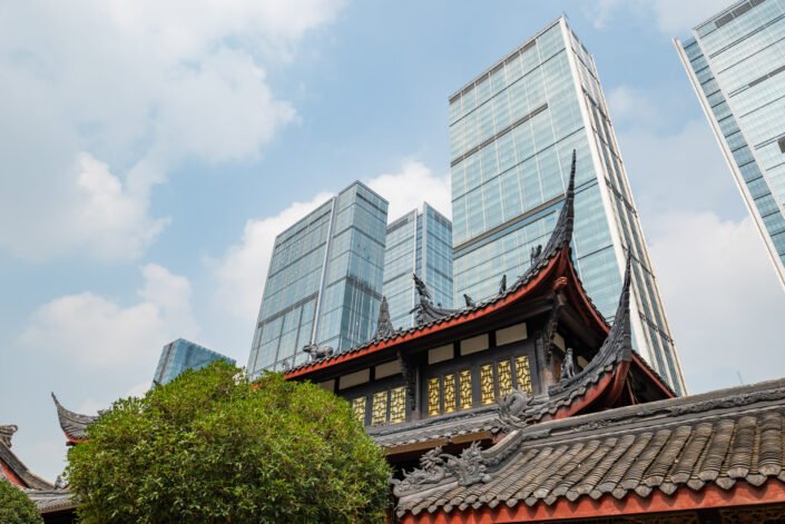 Daci buddhist temple buildings and modern skyscraprers against blue sky in downtown Chengdu, Sichuan province, China