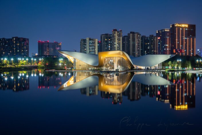 Chengdu Tianfu Art Museum reflecting in a lake at night, Chengdu, Sichuan province, China