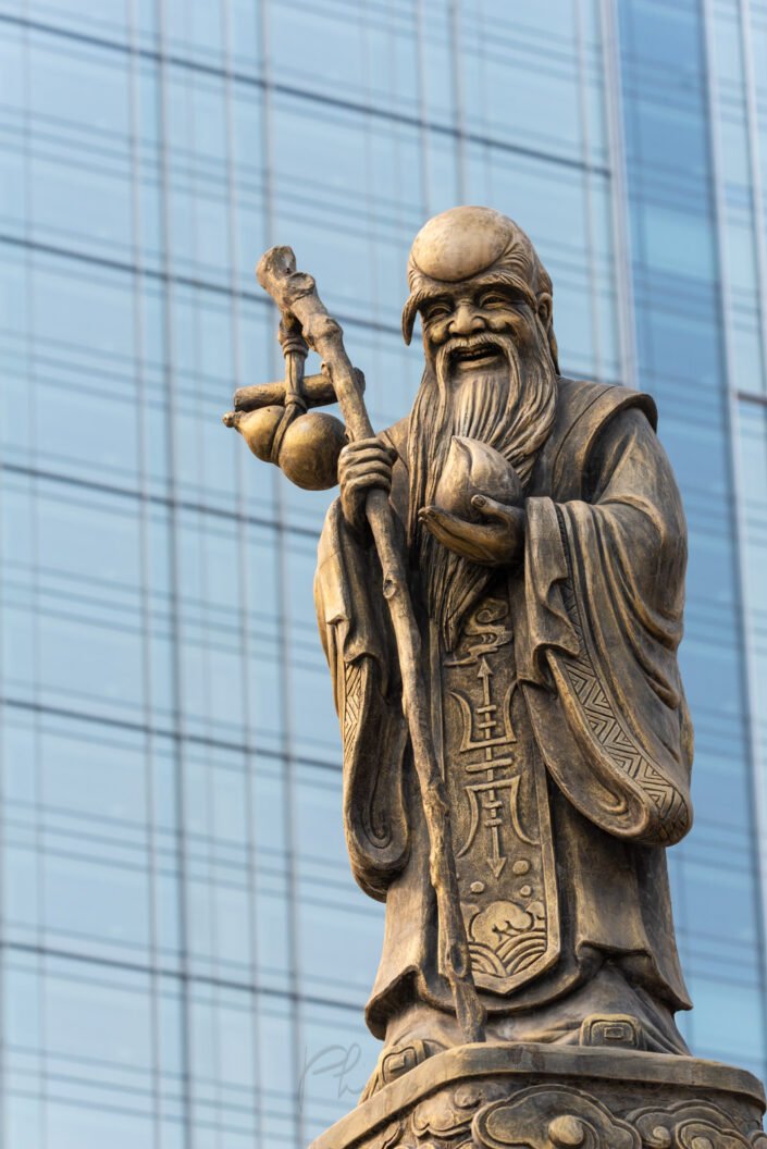 Decoration sculpture on Daci buddhist temple roof against modern building in Chengdu, China