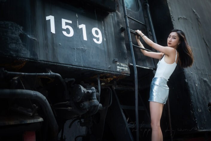 Young woman hanging on a steam train portrait in summer, Chengdu, Sichuan province, China