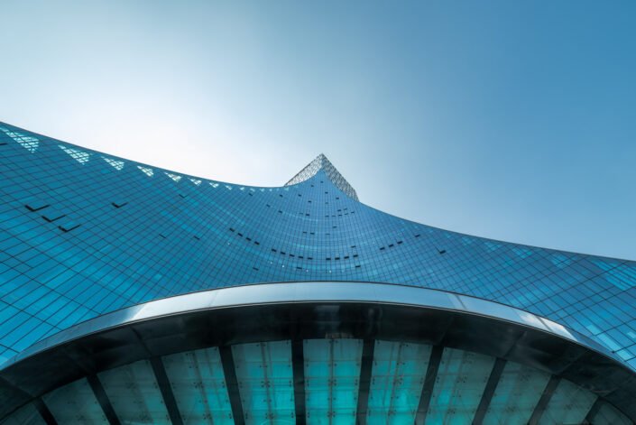 CCEC Modern curved glass building facade reflecting clear blue sky in Chengdu, Sichuan province, China