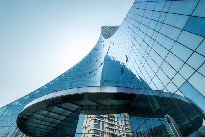 CCEC Modern curved glass building facade reflecting clear blue sky in Chengdu, Sichuan province, China