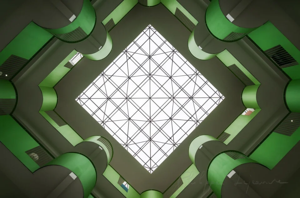 Modern building green atrium directly below view with natural light coming from transparent ceiling