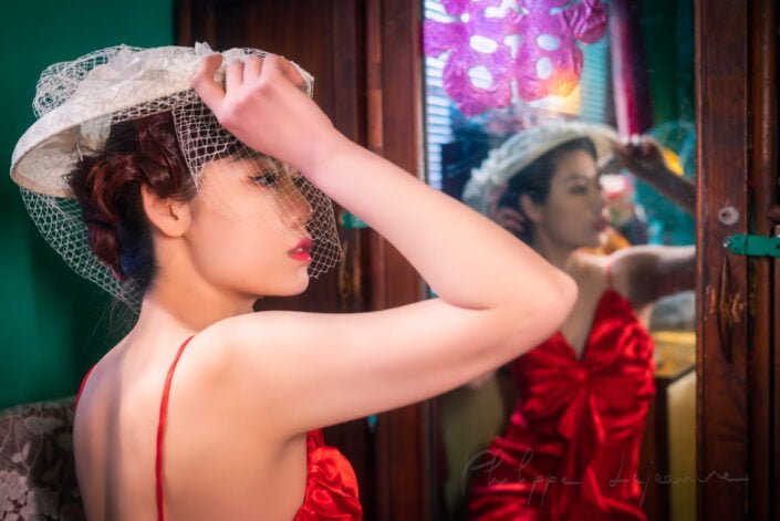 Young woman with a red and a white hat reflecting in a mirror vintage portrait, Chengdu, Sichuan province, China