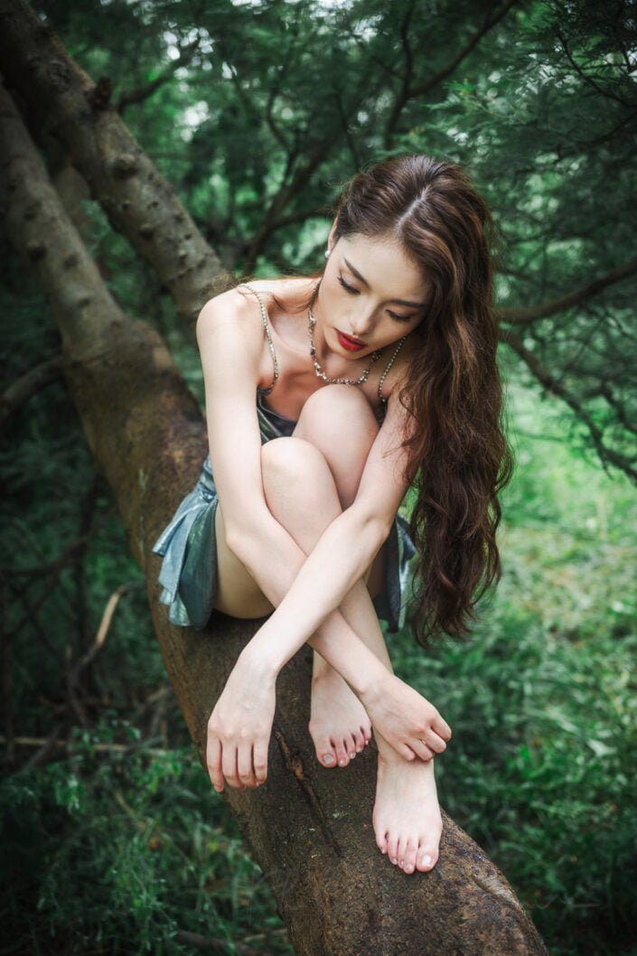 Young woman portrait on a tree in Qinglonghu park, Chengdu, Sichuan province, China