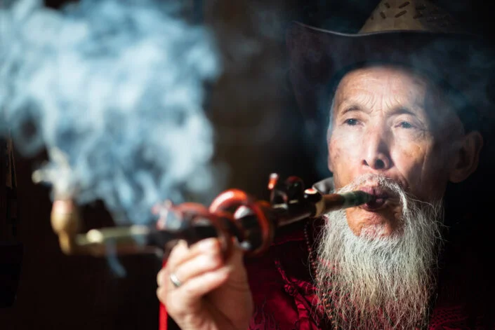 Portrait of an old chinese man smoking in an ancient tearoom, Pengzhen teahouse, Shaungliu, Chengdu, Sichuan province, China