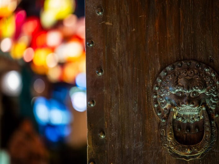 Chinese door knocker against chinese lanterns illuminated at night for the year of the dragon in DongMenShiJi market Chengdu, Sichuan province, China
