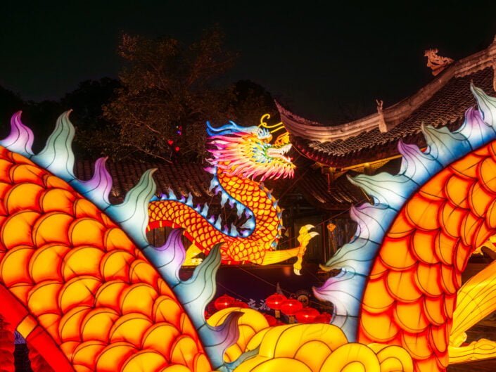 Dragon lanterns illuminated at night with red Chinese lanterns for the year of the dragon in DongMenShiJi market Chengdu, Sichuan province, China