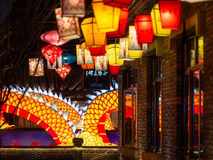Dragon sculptures illuminated at night with red Chinese lanterns for the year of the dragon in DongMenShiJi market Chengdu, Sichuan province, China