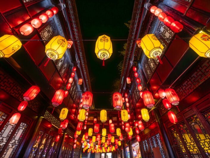 Red and yellow Chinese lanterns with Sichuan opera faces illuminated at night, Chengdu, Sichuan province, China
