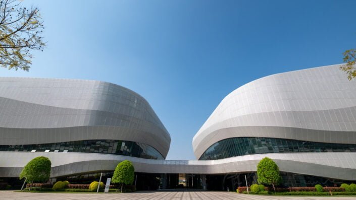 Chengdu, Sichuan province, China - March 29, 2024 : Gaoxin sport center with a unique, futuristic design. The center is located in the south of the city and is surrounded by trees and other greenery. The sky is blue and the sun is shining