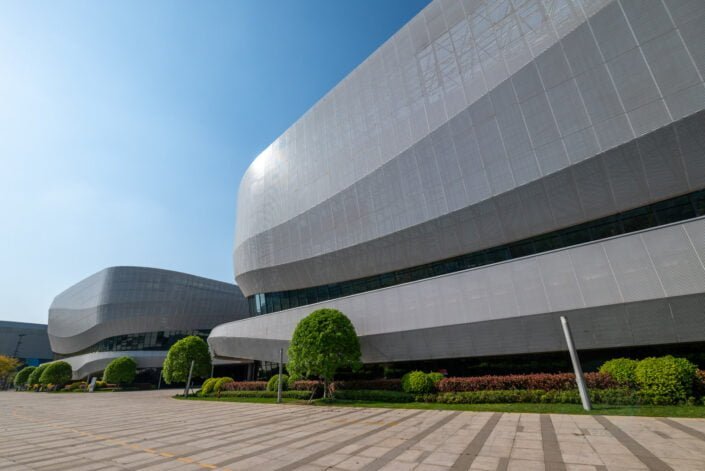 Chengdu, Sichuan province, China - March 29, 2024 : Gaoxin sport center with a unique, futuristic design. The center is located in the south of the city and is surrounded by trees and other greenery. The sky is blue and the sun is shining