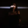This image captures a moment of tranquility featuring a woman in an elegant pose against a dark background. The soft glow illuminates her face and the earring she wears, adding a sense of mystery and elegance to the scene. Model : Fanny, Location: SKP, Chengdu, Sichuan province, China