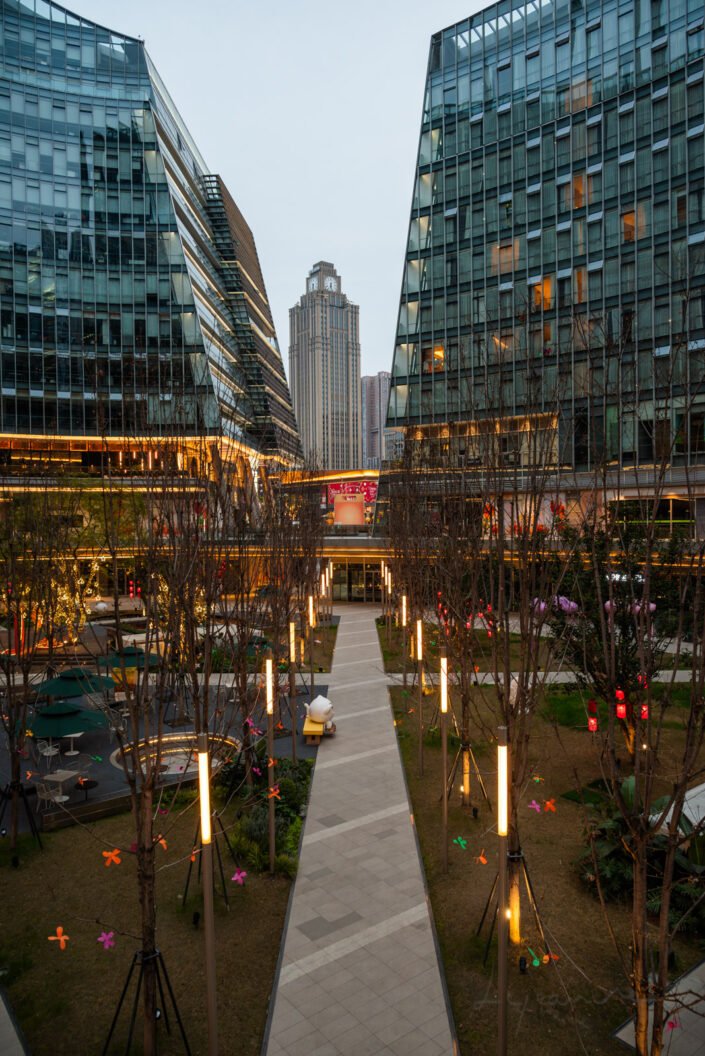 Contemporary architecture of Shiguang Square in Baoli Shi, Chengdu, showcasing sleek high-rise buildings framing a prominent clock tower.