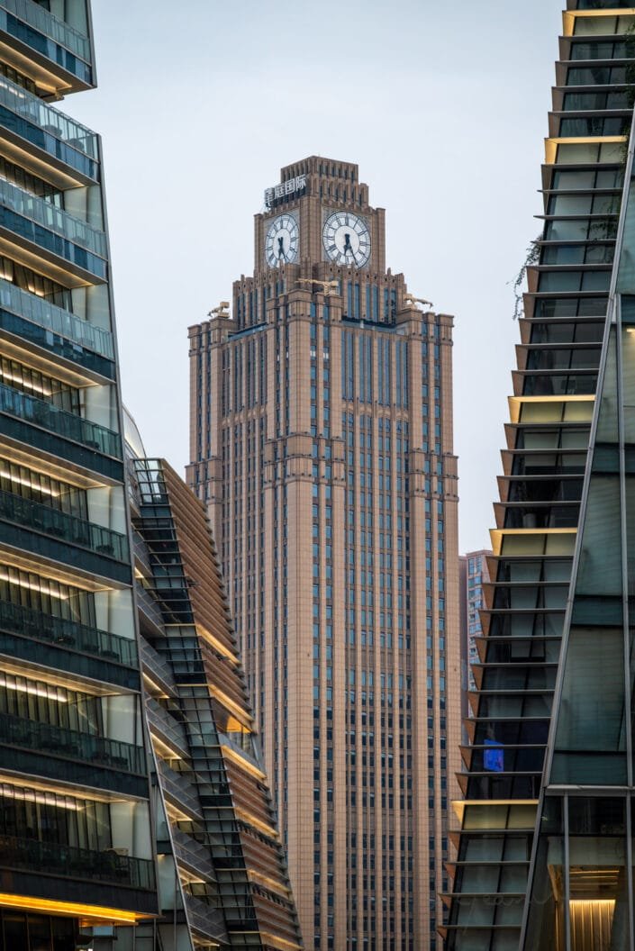 Contemporary architecture of Shiguang Square in Baoli Shi, Chengdu, showcasing sleek high-rise buildings framing a prominent clock tower.