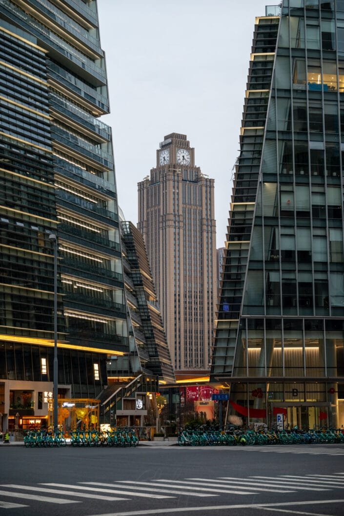 Contemporary architecture of Shiguang Square in Baoli Shi, Chengdu, showcasing sleek high-rise buildings framing a prominent clock tower.